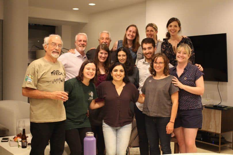 A large group of approximately 15 Meridian staff members stand together looking and smiling at the camera.